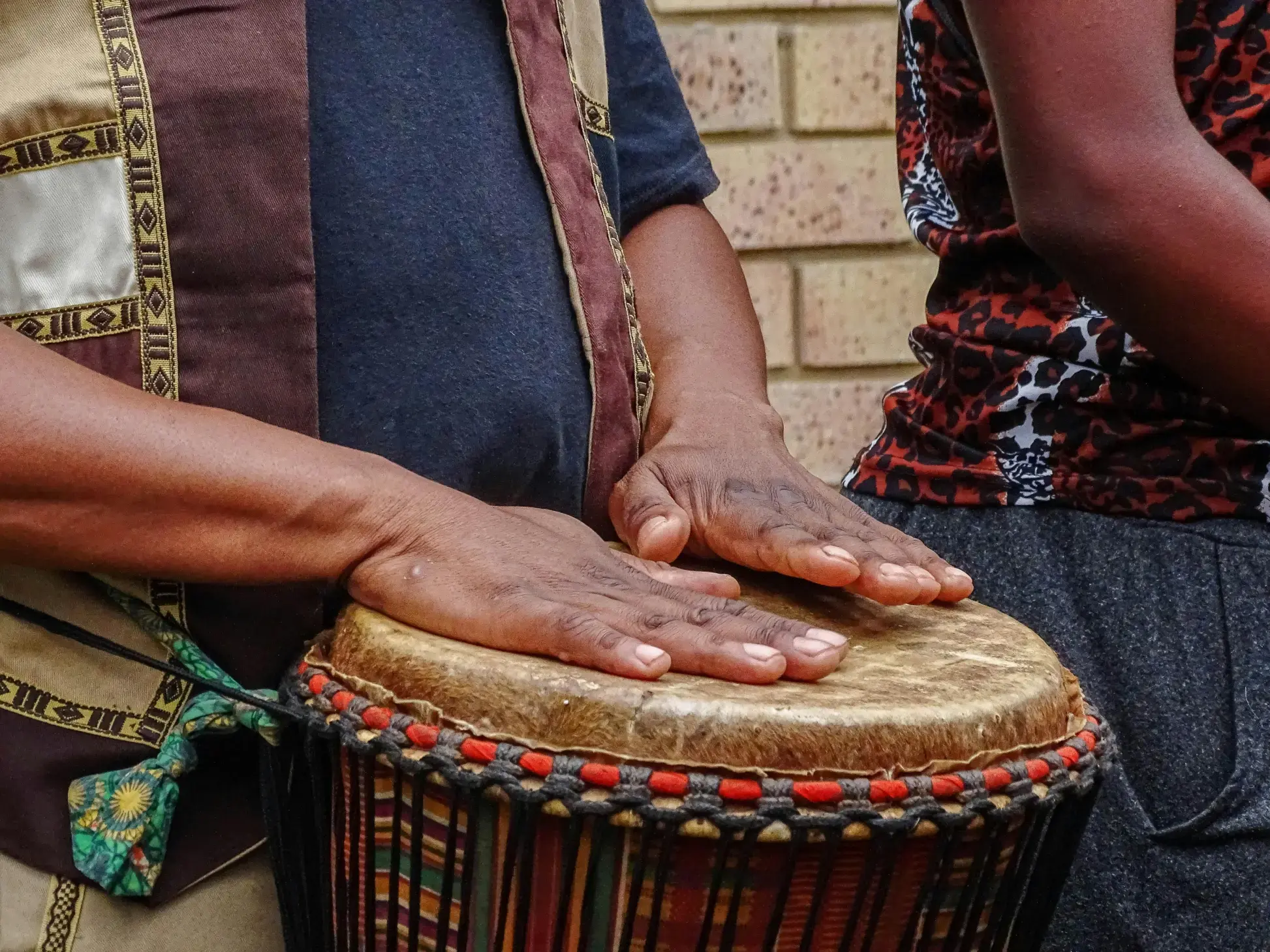 person playing a djembe drum